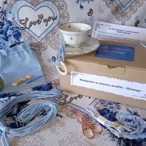 Le kit DIY pour créer une mangeoire à oiseau modèle Mésange exposé avec la tasse, le fils, les perles, la notice