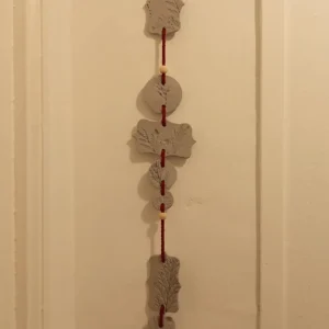 Suspension d'impression végétale sur argile auto durcissante, fil bordeau