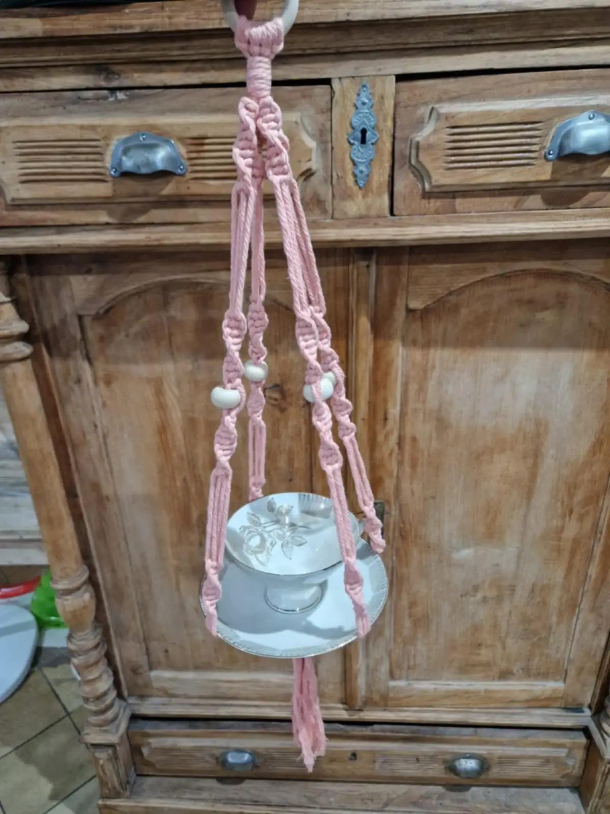 Une mangeoire rose fait main par un kit DIY, suspendu dans un arbre