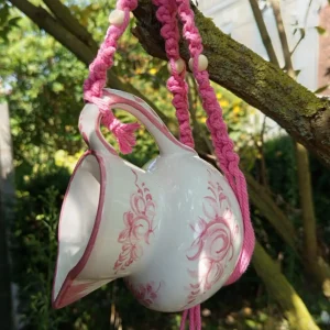 Mangeoire colibri pot de lait couleur rose suspendu dans un arbre
