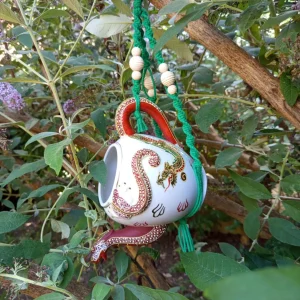 Mangeoire théière dragon japonais modèle Mésange, suspendu dans un arbre.