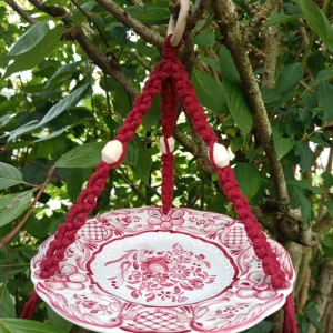 Mangeoire assiette bordeaux suspendue dans un arbre