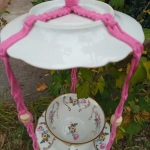 Mangeoire chapeau rose suspendue dans un arbre