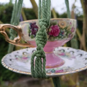 Mangeoire romantique rose et kaki suspendue dans un arbre