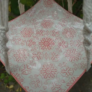 Mangeoire assiette corail suspendue dans un arbre